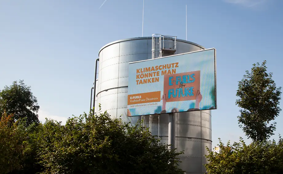 Foto: Silo mit Aktionstafel "E-Fuels for Future: Klimaschutz könnte man tanken"